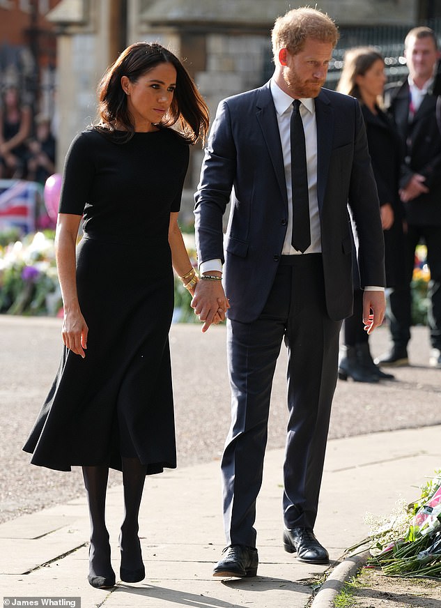 The Duke and Duchess of Sussex view the tributes left behind after the death of Queen Elizabeth II at Windsor Castle