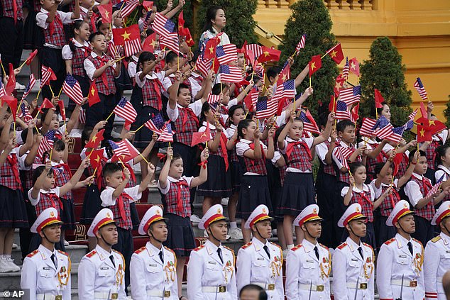 Dozens of schoolchildren holding up both American and Vietnamese flags took part in the welcome ceremony for President Joe Biden at the presidential palace on Sunday