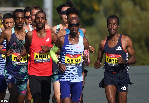 Farah finished in 1:03:28, while Ethiopia's Tamirat Tola (left) won the men's elite race