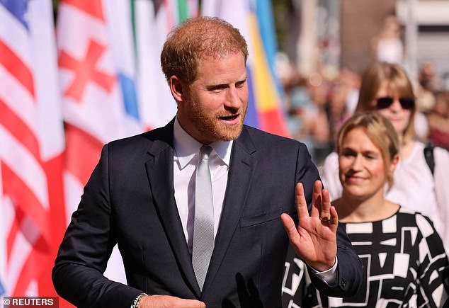 As Harry (pictured) waved to the gathered crowd, he kept his hand on the button of his blazer in what Judi James described as a barrier gesture