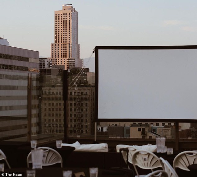 For Fork n' Film, tables are set in front of a screen on a roof in Los Angeles