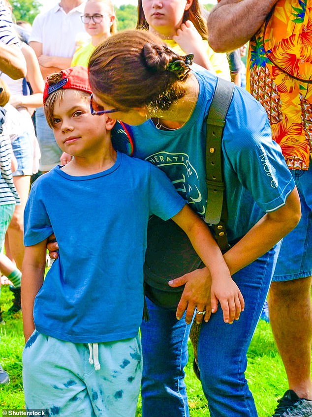 Crown Princess Victoria is pictured hugging her youngest son, Prince Oscar, who is seven