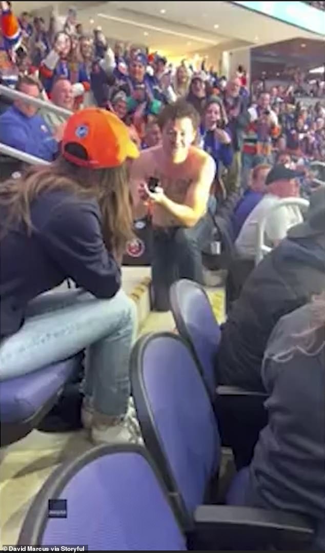 The man proposed in the middle of a hockey game with the words 'PLZ SAY YES' written on his shirt