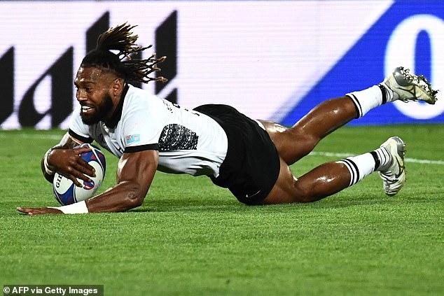 Fiji's Waisea Nayacalevu dives to score a try during the first half of an enthralling encounter