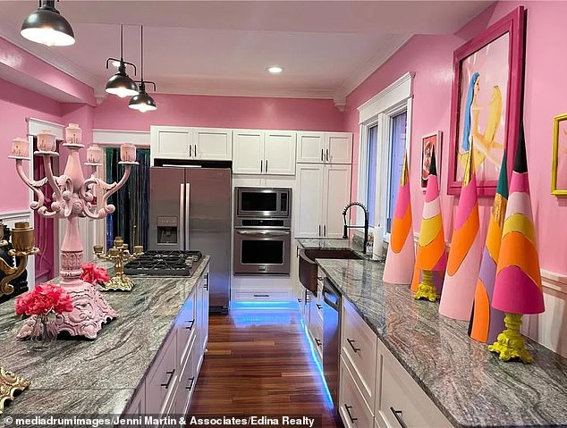 The kitchen features gray marble worktops, wooden floors and the latest appliances, as well as pink, yellow and orange Christmas trees for decoration