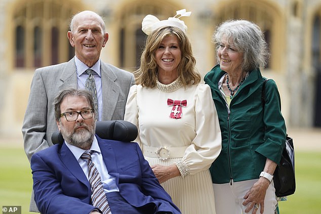 Journey: Doctors put him in a medically induced coma and on a ventilator and he was in hospital for 13 months (Kate and family pictured receiving her OBE in June)