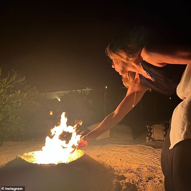 Staying warm: The photo dump continued, with Jennifer in another snap enjoying a night by the fire, warming her hands close to the flame