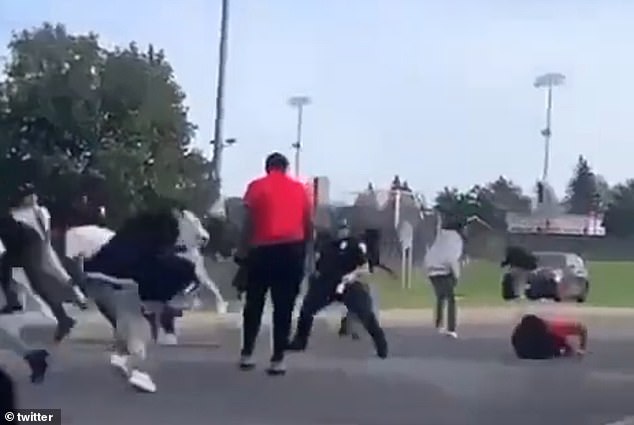 The injured security guard, seen far right, was taken to hospital and remains in critical condition - as a 16-year-old suspect has been arrested and charged with attempted murder