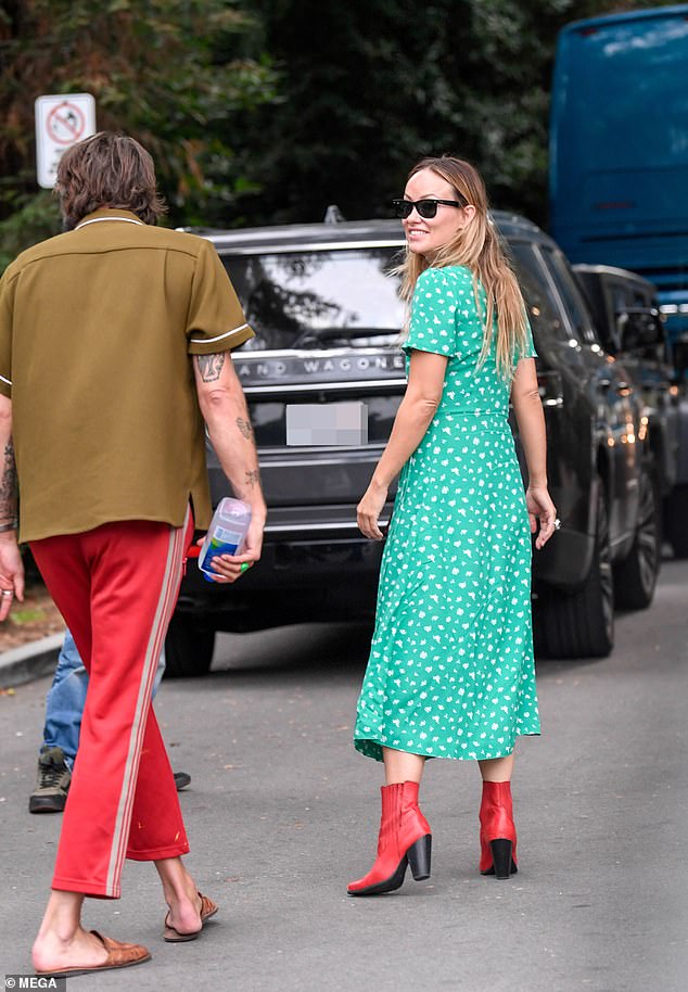 Smiles: The House alum, 39, looked summery in a green and white print, midi-length dress that she paired with red boots and a red handbag