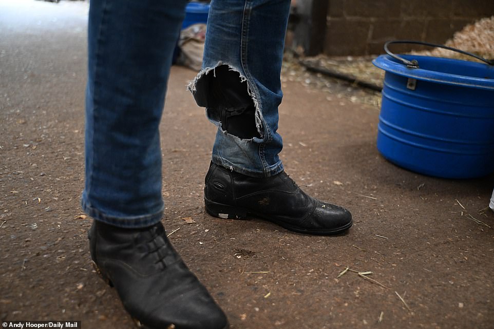 Time to buy new jeans?  A huge tear can be seen in one rider's trousers as they continue to work hard in the stables