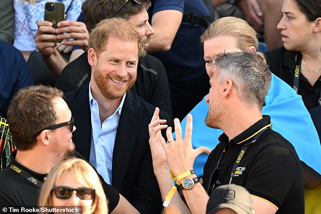 Prince Harry addresses a fellow spectator today during the Invictus Games in Düsseldorf