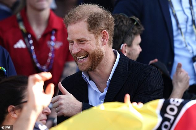 Prince Harry greets a spectator today at the athletics final of the Invictus Games