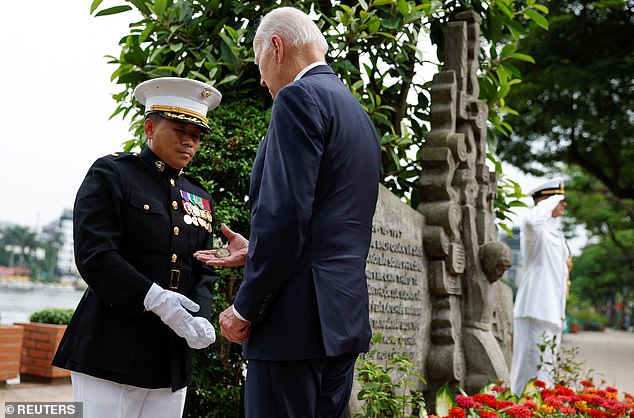 President Joe Biden gave presidential challenge coins to the Navy and Marine Corps officers standing at the John McCain Monument in Hanoi, Vietnam, on Monday