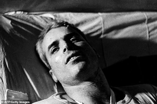 A 1967 photo shows Naval Air Force Major John McCain lying in bed in a Hanoi hospital after his plane was shot down