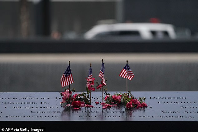 American flags and flowers line the memorial pond at the National September 11 Memorial