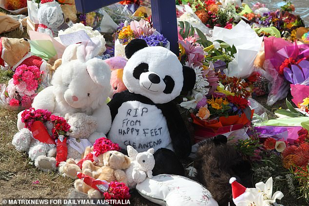 Flowers, hugs and tributes are seen outside Hillcrest Primary School in Devonport, Tasmania in December 2021