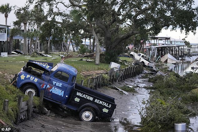 Pickup trucks and debris lie strewn in a canal in Horseshoe Beach, Florida, following the passage of Hurricane Idalia, Wednesday, August 30