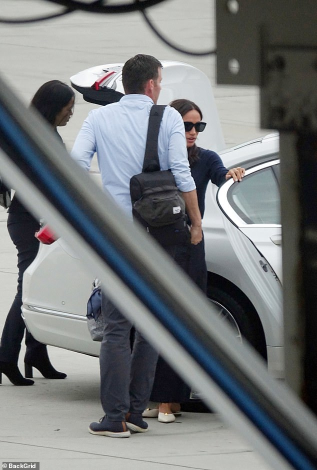 Meghan steps out of the car as a member of airport staff retrieves her belongings from the trunk