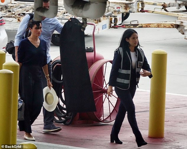 LAX staff lead the Duchess of Sussex to the departure room