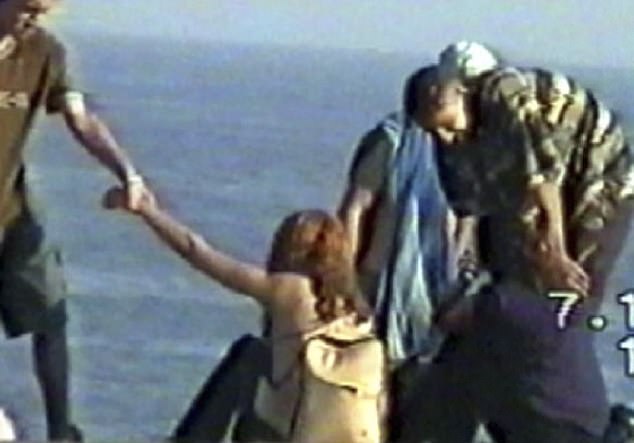 Mohammed Skaf (left) is seen trying to lift a girl from the sand, while Tayyab Sheik (right) leans over the other girl in October 2000.  The girls walked away unharmed.