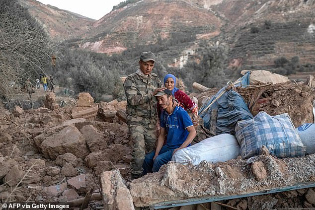 A Moroccan soldier comforts a man sitting on the ruins of a house in the mountainous area of ​​Tizi N'Test