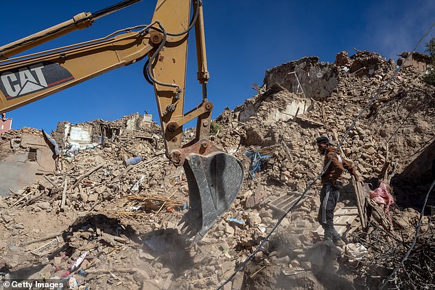 An excavator digs through the rubble of collapsed buildings in Douz on September 11, 2023