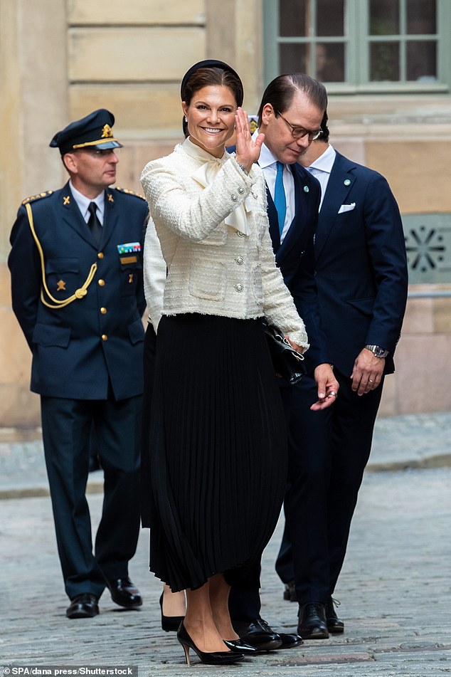 Crown Princess Victoria cuts an elegant figure in a flowing black pleated skirt, a cream-colored jacket with silver buttons and a blouse with a bow