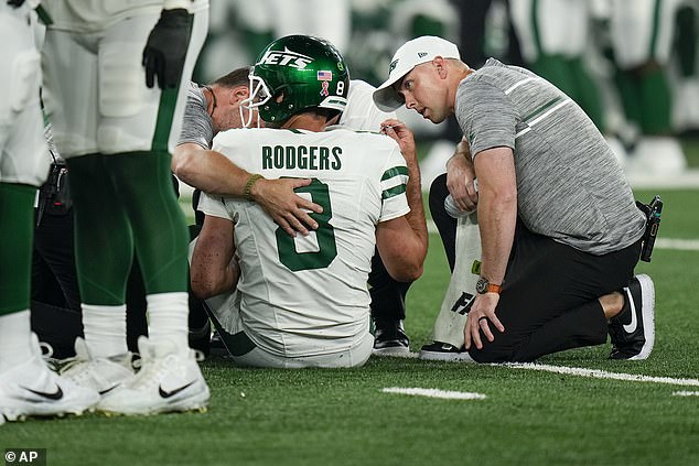 Jets quarterback Aaron Rodgers (8) is treated on the field during the first quarter