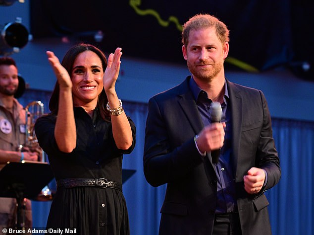 Prince Harry sat mostly in the background during his wife's speech, but said a few words at the end when she handed him the microphone