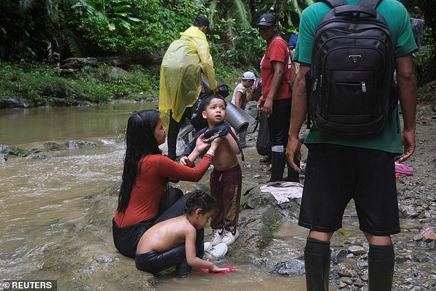 Migrants take a break to freshen up before continuing their journey to the US border, in Acandi, Colombia, July 9, 2023