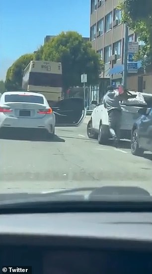 The thief grabs bags and then runs back to the waiting car