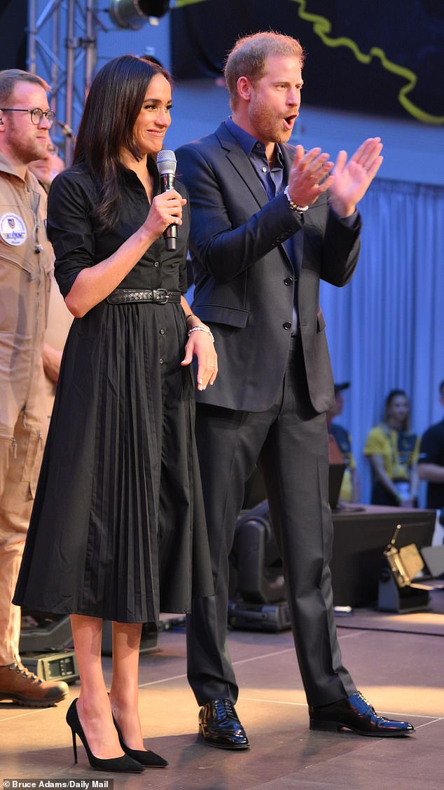 The Duchess of Sussex stunned in a black shirt dress with button detailing, a belted waist and a pleated skirt as she attended her first Invictus Games event in Dusseldorf this evening