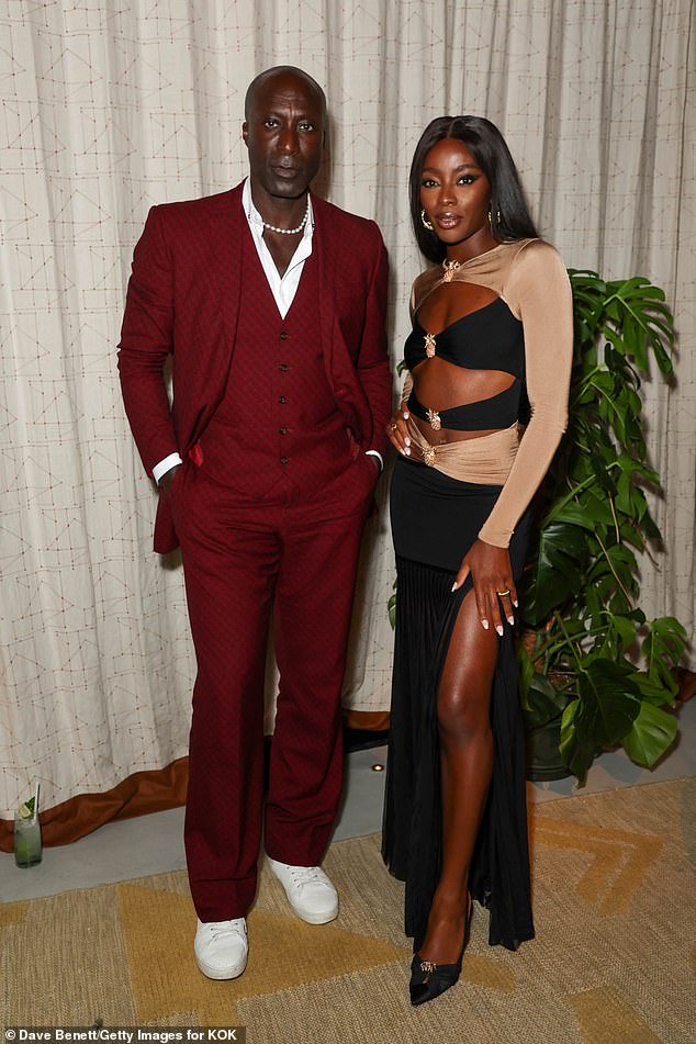 Posing: AJ was accompanied by fashion designer Ozwald Boateng, who cut a friendly figure in a red suit