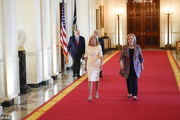 Jill Biden and Hillary Clinton walk into the East Room of the White House