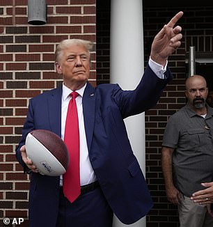 Donald Trump passes out football during campaign in Iowa