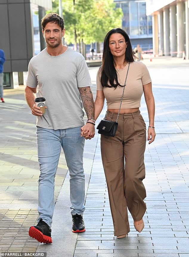 Stylish: Meanwhile, his wife showed off her toned stomach in a beige cropped T-shirt and brown trousers