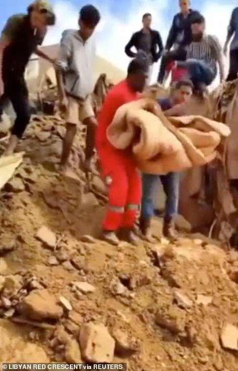 Volunteers from the Libyan Red Crescent were pictured pulling a young child from the rubble