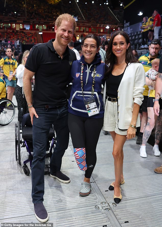 Harry and Meghan then posed with Team USA's Annika Hutsler, who is competing in the 100M and 200M races