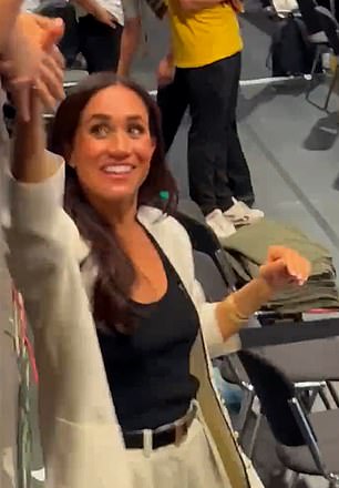 Meghan reached out and shook hands with fans who shouted 