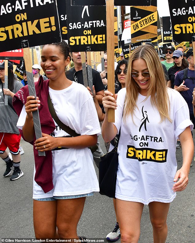 Taking a stand: The Barbie actress, 33, waved a poster as she marched with an army of protesters from Netflix to Paramount Studios