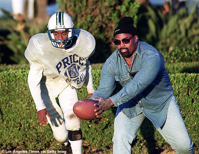 Stanley Wilson Jr.  (L) prepares to receive the ball from his father Stanley Wilson Sr.  in the nineties