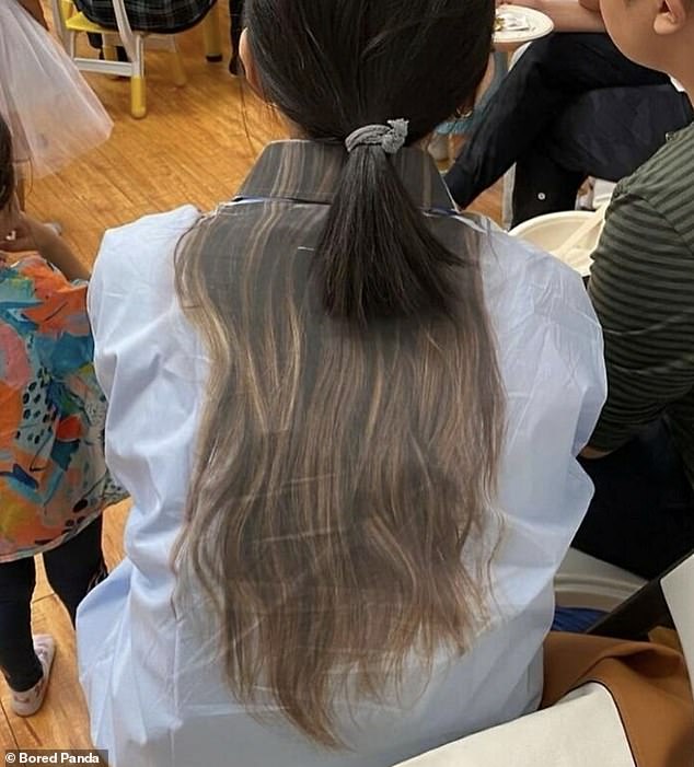 A young girl had fake hair printed on the back of her shirt - which looks like her own hair until you notice her little ponytail