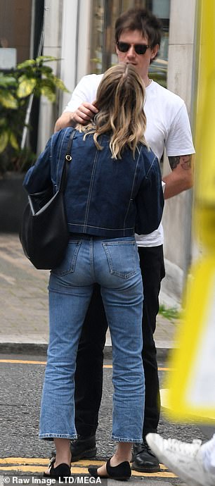 Finishing touches: She completed her look with a pair of strappy flats, while a simple black handbag seemed to be her only standout accessory as she shared an intimate moment with Seed