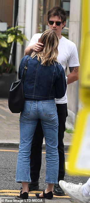 Finishing touches: She completed her look with a pair of strappy flats, while a simple black handbag seemed to be her only standout accessory as she shared an intimate moment with Seed