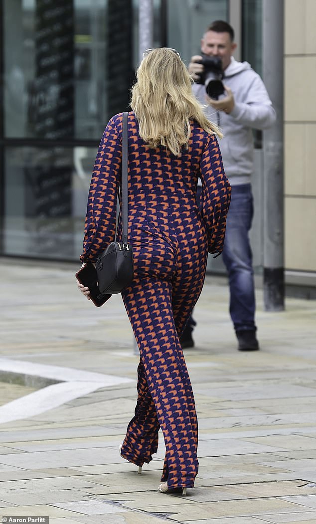 Stylish: She paired her look with white strappy heels and carried a black bag over her shoulder