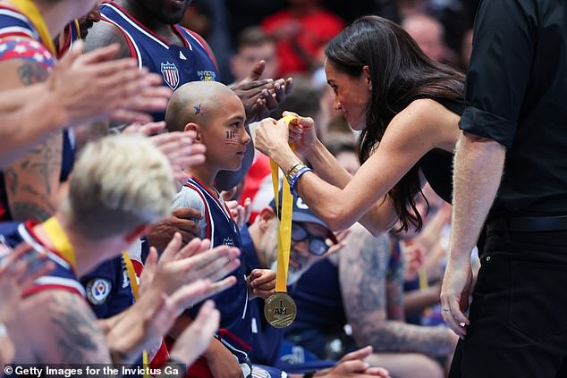 Meghan attends the medal ceremony and presents a medal to the winning team