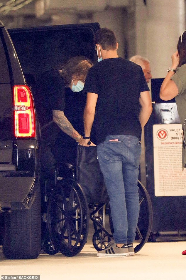 Support: While in Los Angeles on Wednesday, Ozzy was seen getting out of a car and into a wheelchair while a man wearing a face mask stood with his hands on the handles