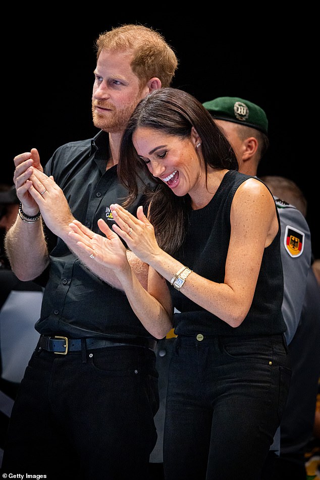 The Duke and Duchess of Sussex held hands, snuggled and leaned lovingly towards each other as they attended the wheelchair basketball final at the Merkur Spiel-Arena in Dusseldorf, Germany