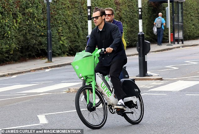 Here they come: The best friends were seen weaving through traffic while riding identical eco-bikes