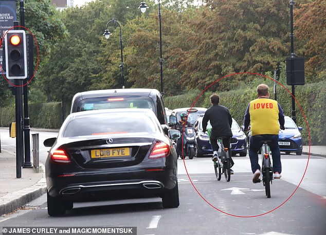 Steady on: They seemed to get their highway code a little confused by cycling through a red light while neighboring cars were waiting in line